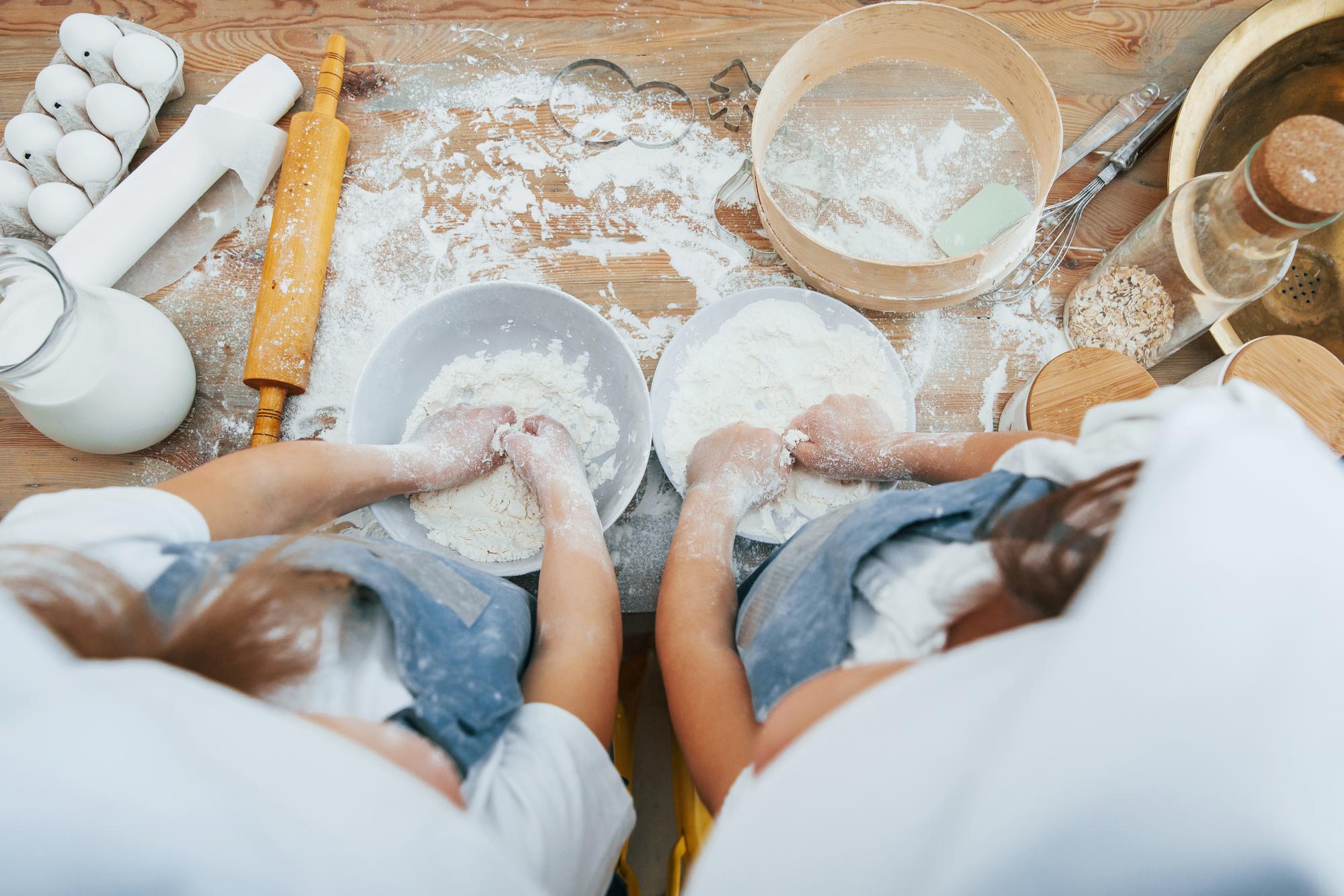Hands kneading dough on floured board